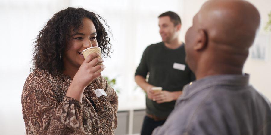 Adults chatting and drinking coffee.