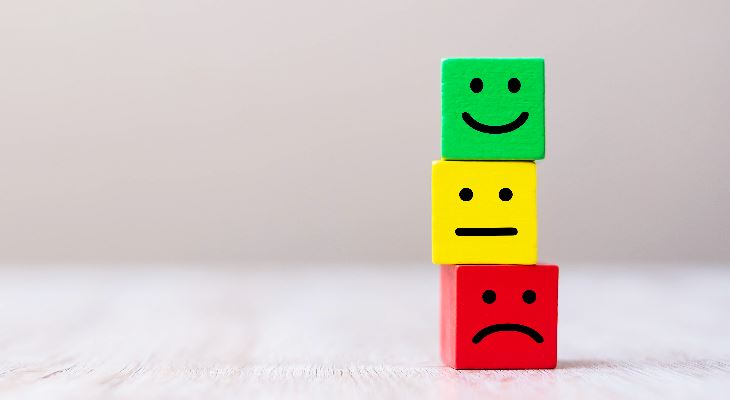 Wooden blocks with happy, indifferent and sad face.