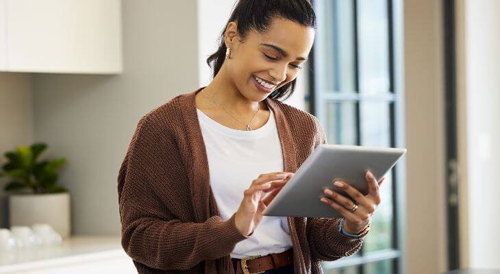 A young woman using a tablet at home.