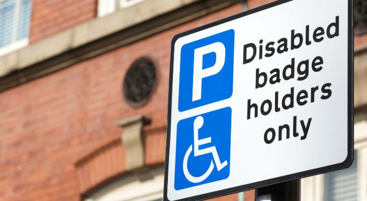 A parking sign that reads &quot;Disabled badge holders only&quot;.