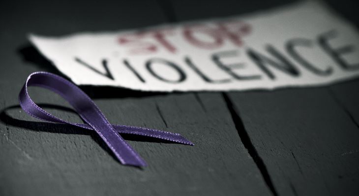 A ribbon lying next to a sign reading, Stop violence.