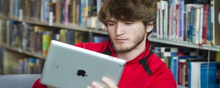 A library customer reading a tablet.