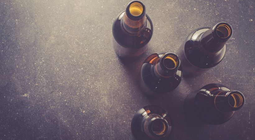 5 empty brown beer bottles.