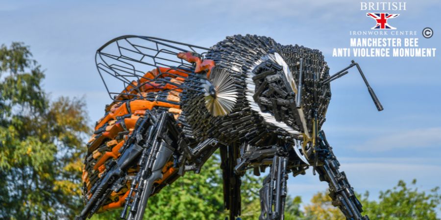 A statue of a bee made out of knives and guns.