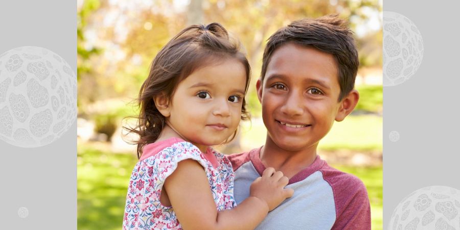 A brother and little sister in the park.