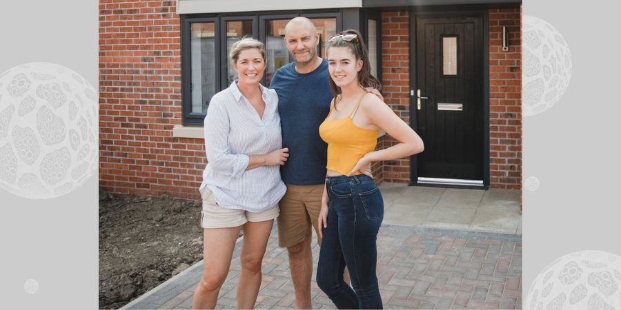 A teenage girl with 2 foster carers outside a house.