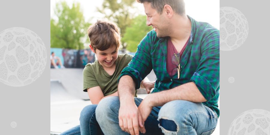 A teenage boy and his dad in a skatepark.