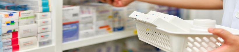 Close up of a pharmacist&#039;s hands holding pill boxes.