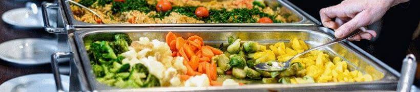 Vegetables laid out in catering trays.