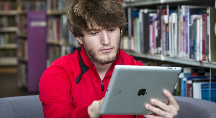 A man using a tablet in Rochdale Central Library.