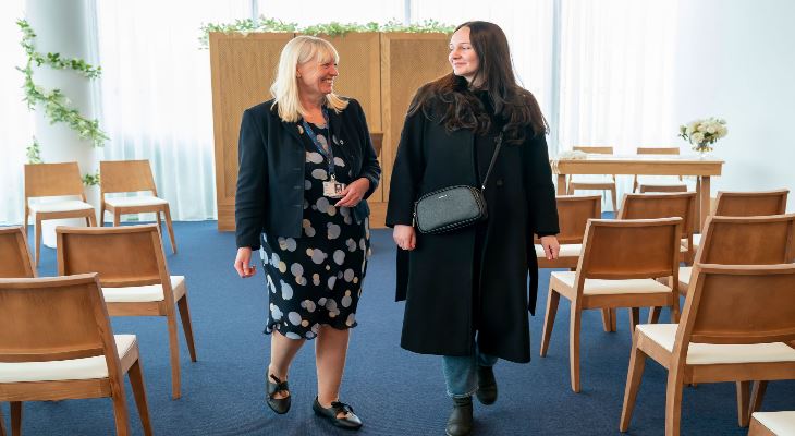 A visitor being shown around the Red Rose Suite at the Rochdale Register Office.