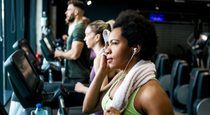 A group of adults running on treadmills.