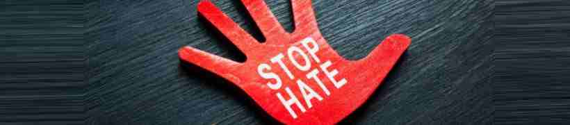 Wooden hand with words Stop hate painted on it.