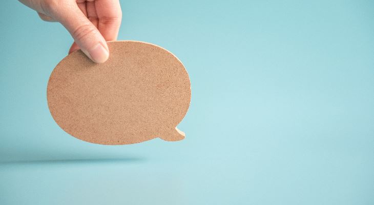 Hand holding a cork speech bubble.