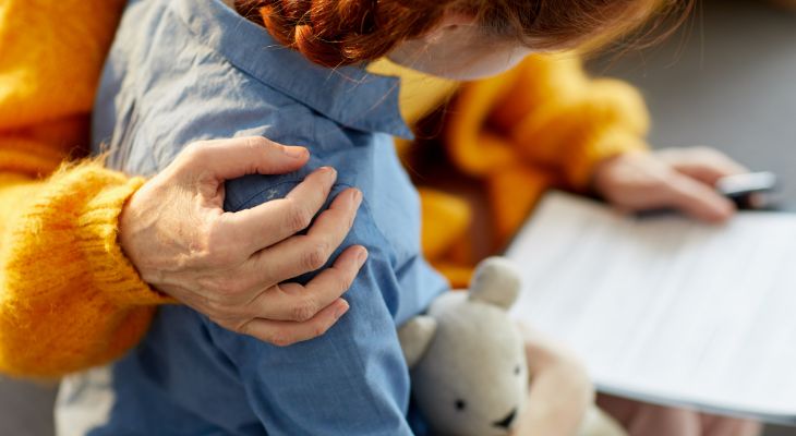 Close up of a woman hugging a child.