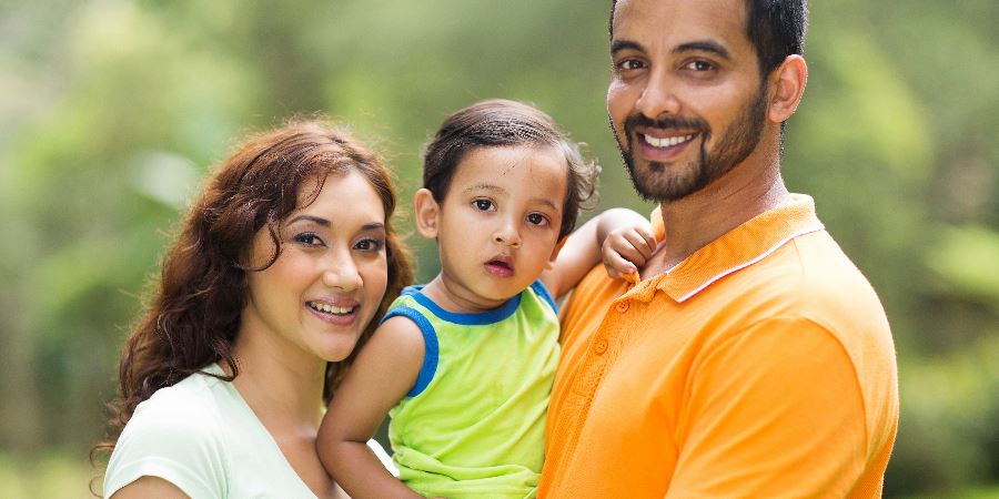 A smiling family with a young child.