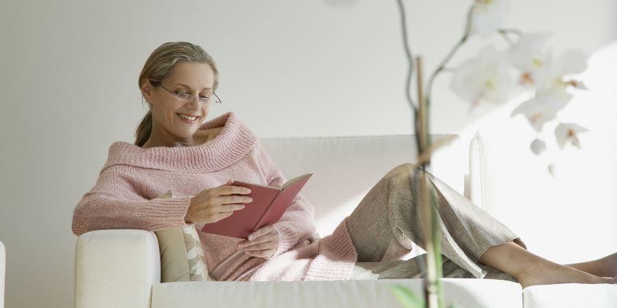 A woman sitting and enjoying a book.