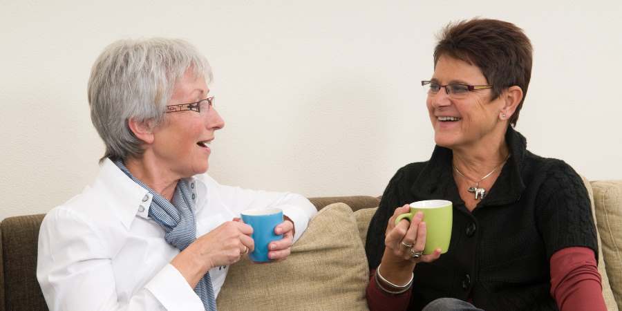 2 people chatting over coffee.