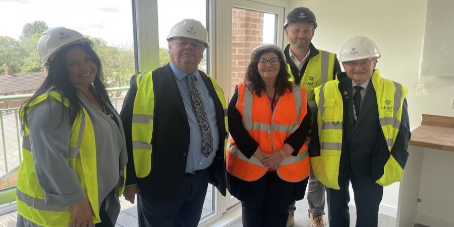 Kim Radevic, Councillor Neil Emmott, Gary Hamer and Councillor Billy Sheerin standing in a flat.
