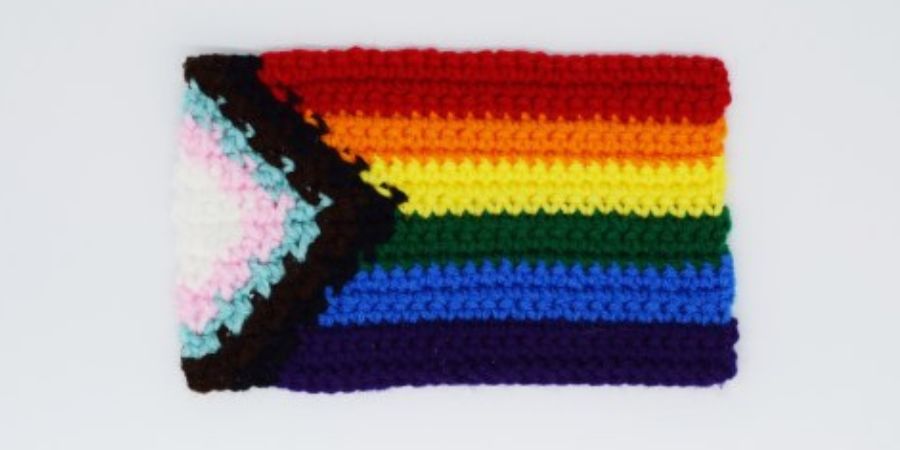 A knitted Pride Progress flag.