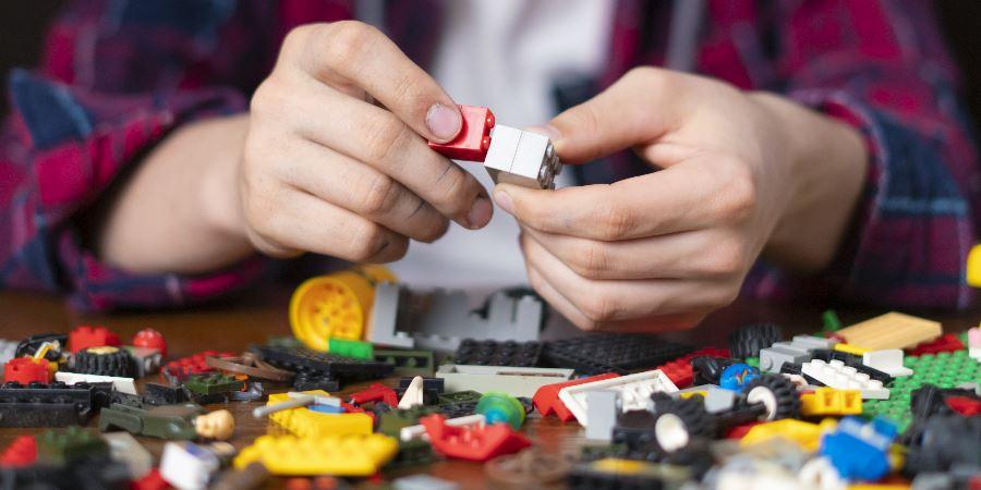 Close-up of hands working on a Lego model.