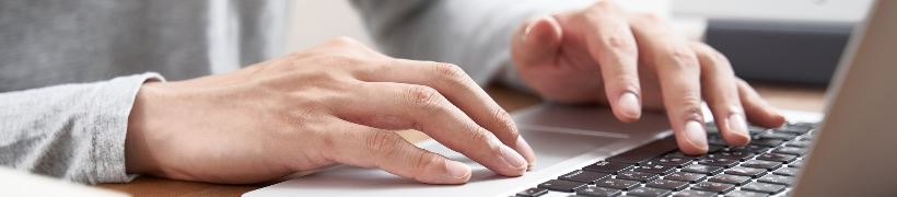 Close up of hands typing on a laptop.