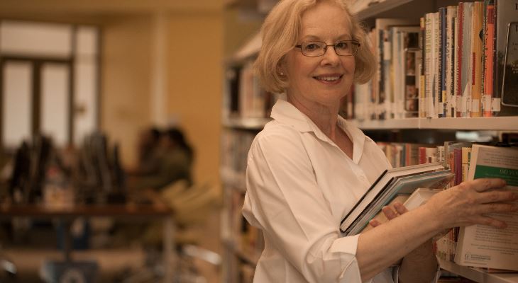 A smiling volunteer working in a library.