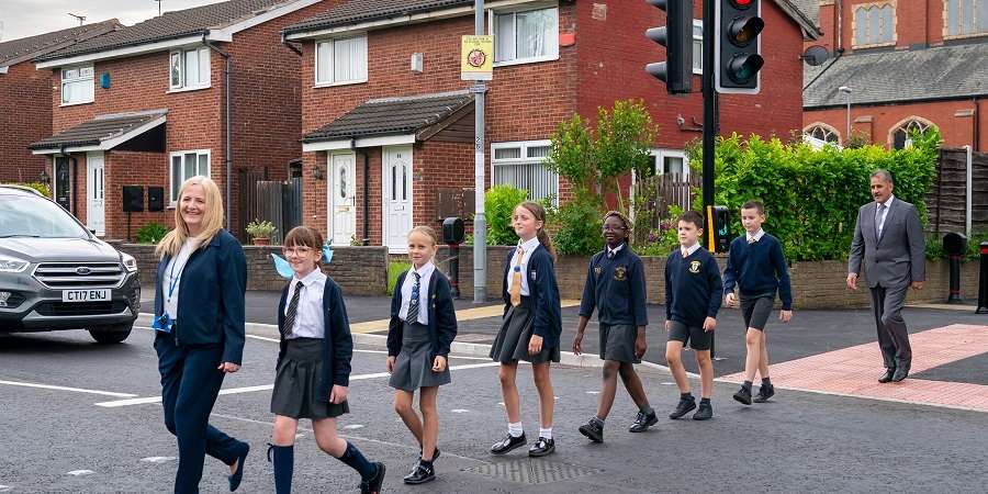 Joanne Clinch using the new crossing, followed by pupils from St Peters and Councillor Shah Wazir.