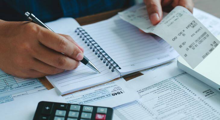 Close of hands working on household bills.