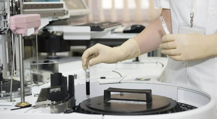 A laboratory assistant processing vials.