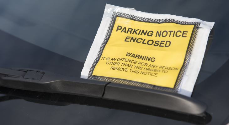 A parking ticket stuck to a windscreen.