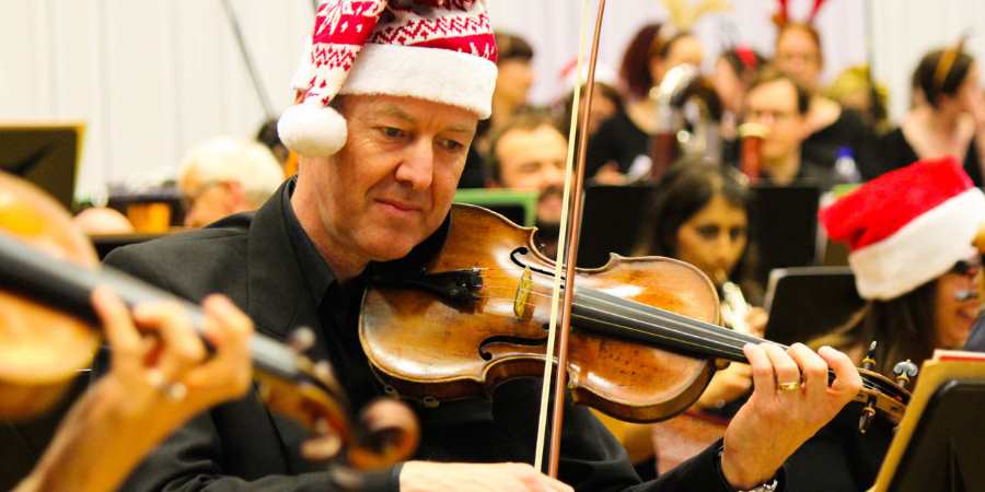 Orchestra members wearing Santa hats.