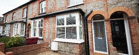 A front door and window of a terraced house.