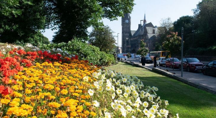 Rochdale Town Hall in the background and a verge of blooming flowers.