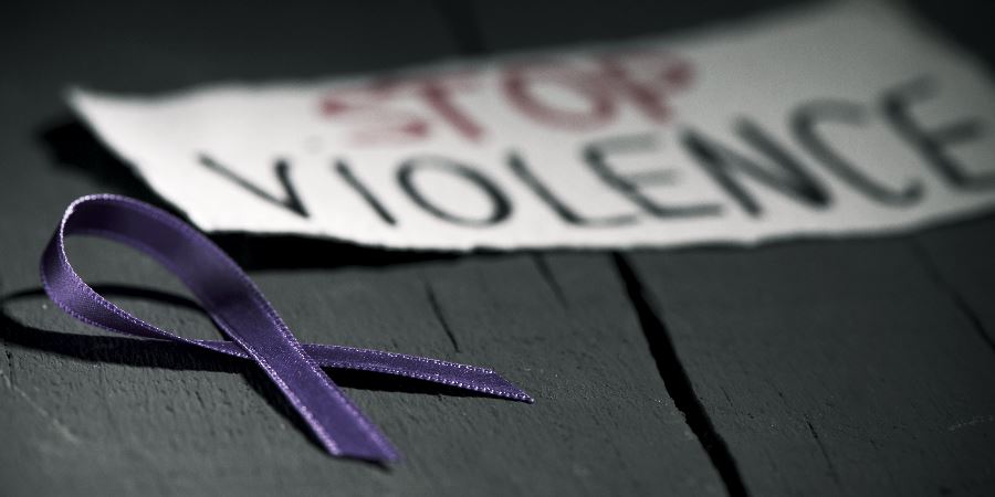 A purple ribbon next to a note reading, stop violence.