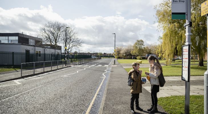 2 children waiting for a school bus.