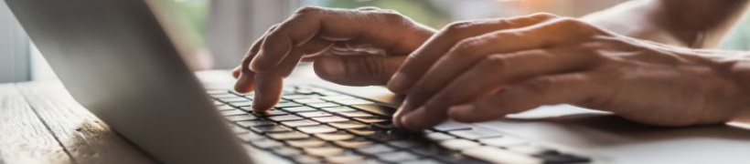 Close up of hands typing on a laptop.