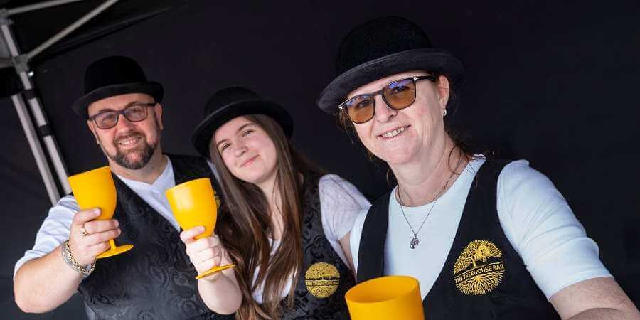 Staff from the Tree House Bar holding drinks.