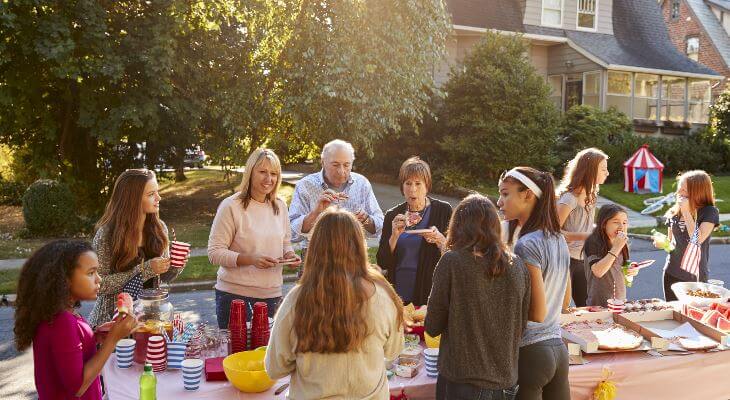 Neighbours eating and socialising at a party in the street.