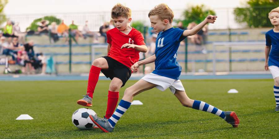 2 boys playing football.