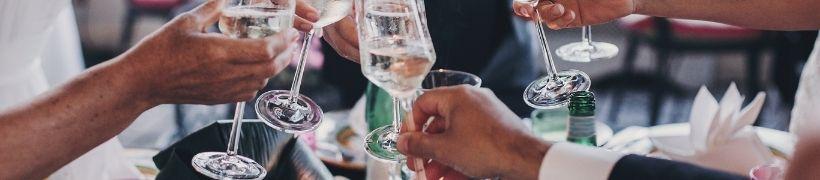 Close up of hands holding wine glasses in a toast.