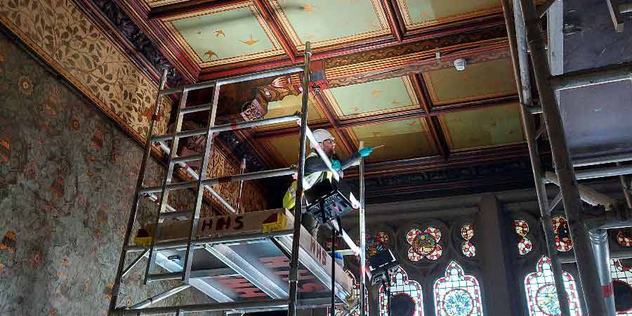 A worker examining ceiling tiles in Rochdale Town Hall.