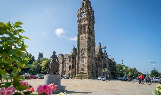 Rochdale town hall in the distance with a rose bush in the forefront