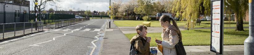 2 schoolchildren waiting for the bus.