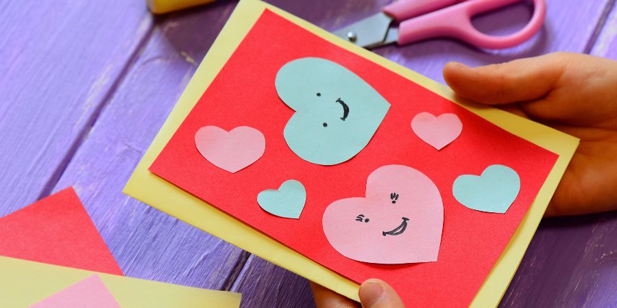 A child holding a homemade Valentine's Day card.