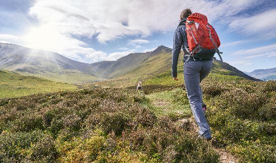 Man walking up a hill with a back pack on