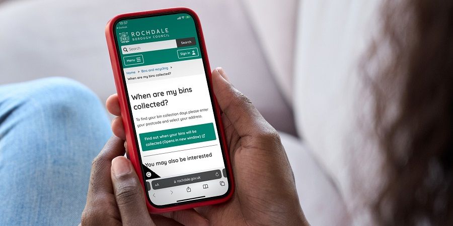 A person checking bin collection days on their mobile device.