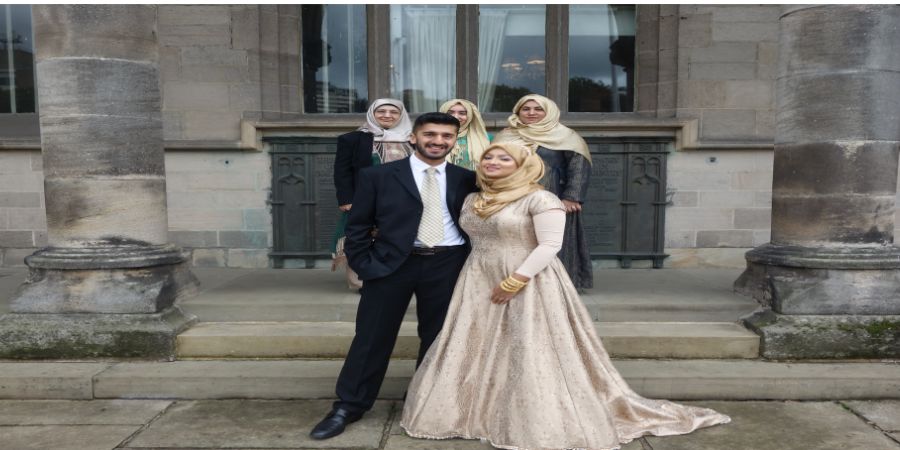 A newly wed couple posing for a photo outside of Rochdale Town Hall.